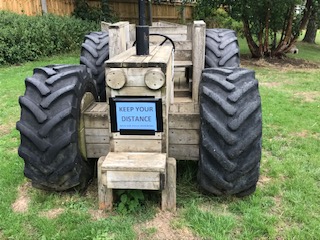 Play tractor showing Keep Your Distance poster